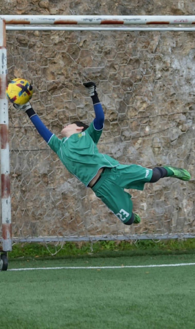 Lucas stretching to tip a shot over the bar